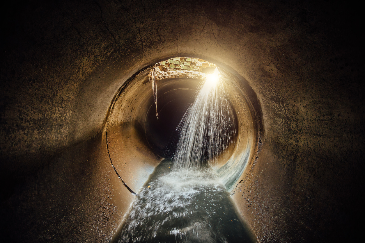 Water pouring into a sewer pipe through a break in the pipe wall